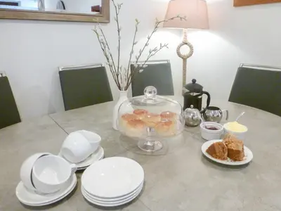 a table with plates and a bowl of donuts on it at Anneth Lowen in Pentewan
