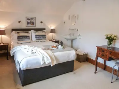 a bedroom with a large bed and a sink at Anneth Lowen in Pentewan