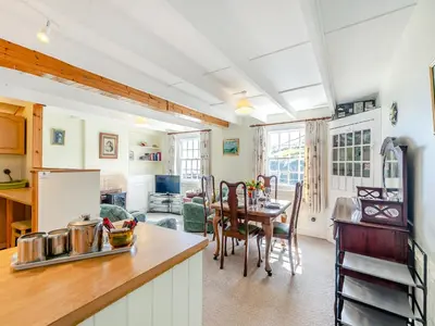 a kitchen with a table and a dining room at Memory Cottage in Mevagissey