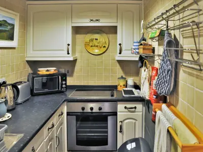 a kitchen with a stove and a microwave at Sea Haven - Tho in Gorran Haven