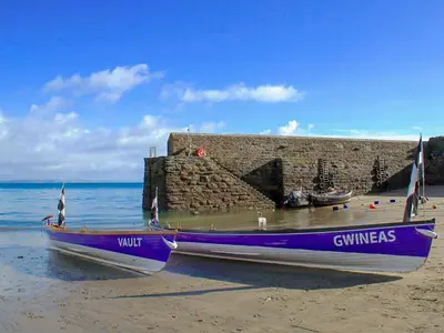 a purple boat sitting on the shore of a beach at Seaview in Gorran Haven
