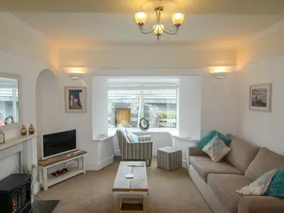 a living room with a couch and a tv at Seaview in Gorran Haven