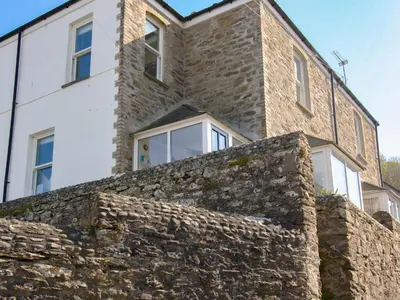 an old stone wall in front of a building at Seaview in Gorran Haven