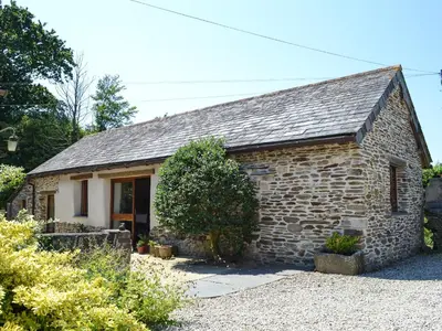 a small stone building with a window at The Old Wash House in Pentewan