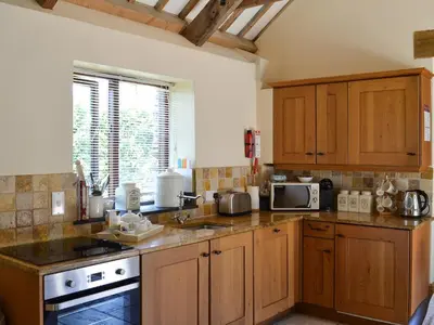 a kitchen with wooden cabinets and a counter top at The Old Wash House in Pentewan