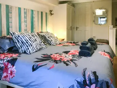 a bed with flowers on it in a bedroom at Puffin Burrow in Portmellon