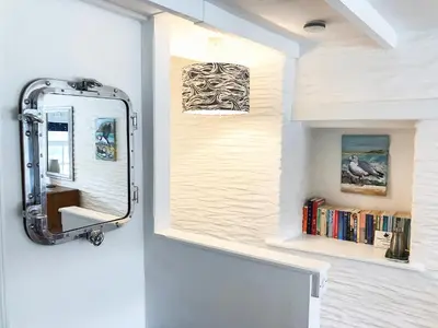 a bathroom with a mirror on the wall at Puffin Burrow in Portmellon