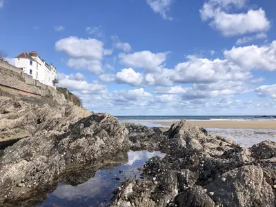 a building sitting on top of a rocky beach at Puffin Burrow in Portmellon