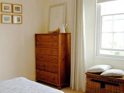 a bedroom with a dresser and a window at The Gables in Gorran Haven
