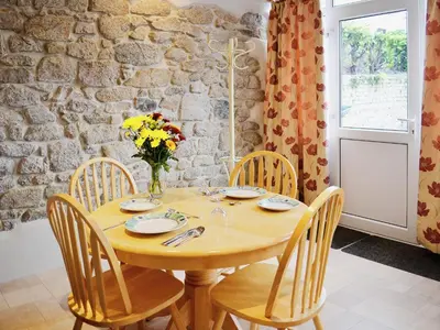 a dining room with a wooden table and chairs at The Old Coach House in St Austell