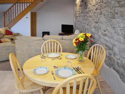 a wooden table with plates and a vase of flowers at The Old Coach House in St Austell