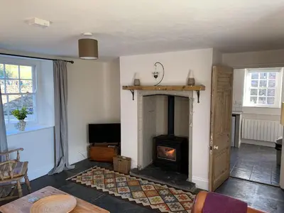 a living room with a fireplace and a fire place at Gewans Farm Cottage in St Austell
