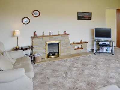 a living room with a fireplace and a tv at Goonlaze in St Austell