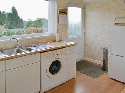 a kitchen with a sink and a washing machine at Goonlaze in St Austell