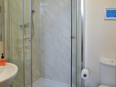 a shower with a glass door in a bathroom at Scholten Lodge in Roche