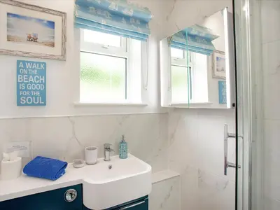 a bathroom with a sink and a shower at Sweet's Close in St Austell