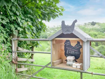 a wooden bird house with a sign on top of it at Sweet's Close in St Austell