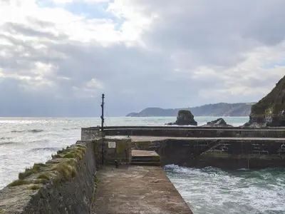 a pier in the ocean next to the water at Sweet's Close in St Austell
