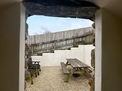 a picnic table and benches in a room with a fence at Millie's Place in Saint Stephen