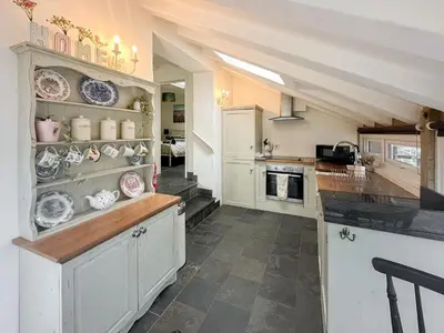 a kitchen with white cabinets and plates on the shelves at Millie's Place in Saint Stephen