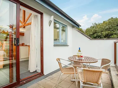 a patio with a table and chairs on a balcony at Villa Gallery- 27073 in Perranwell