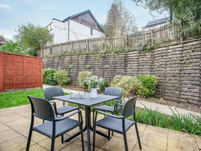 a table and chairs on a patio with a fence at Villa Gallery- 27073 in Perranwell