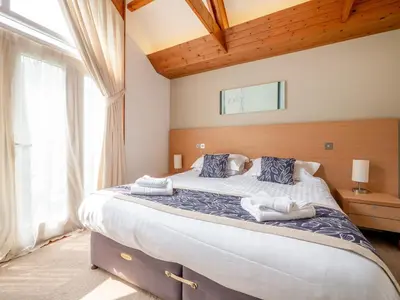 a bedroom with a large bed with towels on it at Villa Gallery - 27074 in Perranwell