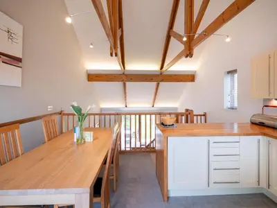 a kitchen with a wooden table and a dining room at Villa Gallery - 27074 in Perranwell