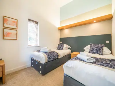 a bedroom with two beds and a window at Villa Gallery-76 in Perranwell