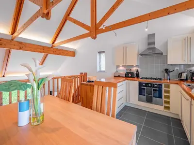 a kitchen with wooden cabinets and a wooden table at Villa Gallery-76 in Perranwell
