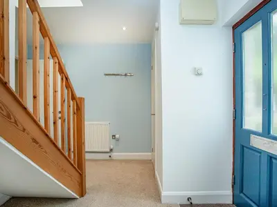a hallway with a blue door and a staircase at Haven -78 in Perranwell