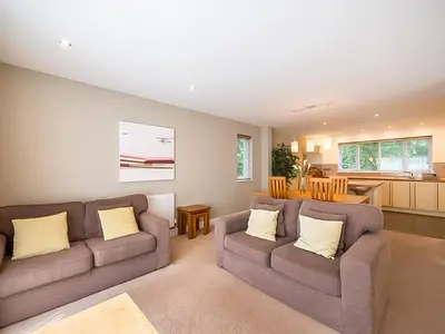 a living room with two couches and a kitchen at Haven -78 in Perranwell