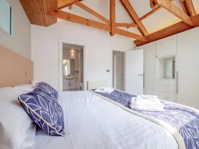 a bedroom with a large bed with blue and white pillows at Haven -79 in Perranwell