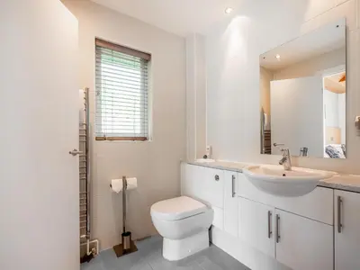 a white bathroom with a toilet and a sink at Haven -79 in Perranwell