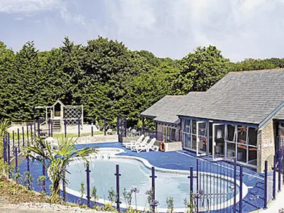 a house with a swimming pool next to a fence at Haven -80 in Perranwell