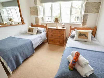 a bedroom with two beds and a mirror at The Stable in Crowan