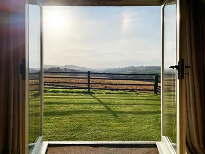 an open door with a view of a field at The Stable in Crowan