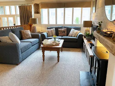 a living room with two couches and a coffee table at Swallows Barn in Crowan