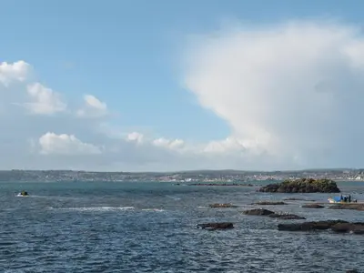 a large body of water with rocks in it at Beach Comber Cottage in Marazion