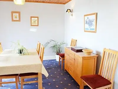 a dining room with a table and chairs and a desk at Suncroft in Praa Sands