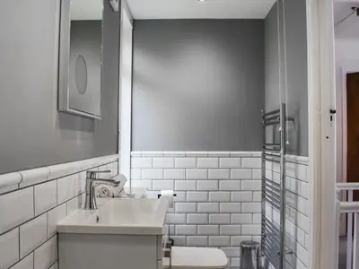 a white bathroom with a sink and a mirror at Hillside in Praa Sands