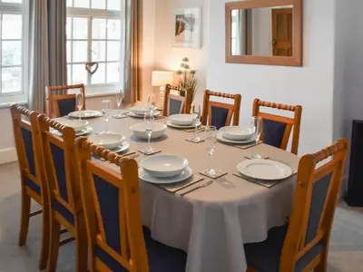 a dining room table with plates and wine glasses on it at Hillside in Praa Sands