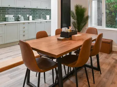 a kitchen with a wooden table and chairs at Hillside in Praa Sands