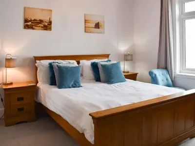 a bedroom with a large bed with blue pillows at Hillside in Praa Sands