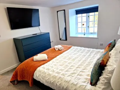 a bedroom with a large bed with towels on it at Very Spacious, Great location. Castle and Sea view in Marazion