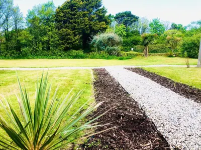a gravel path in a park with a plant at Very Spacious, Great location. Castle and Sea view in Marazion