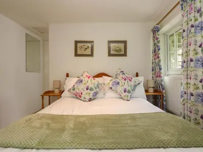 a bedroom with a bed with pillows and a window at Byre in Camelford