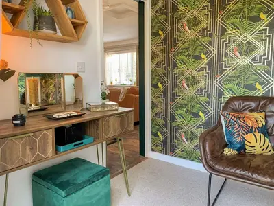 a living room with a couch and a wall at Inny Brook Burrow in Camelford