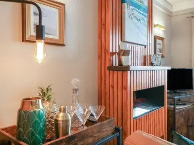 a living room with a table and a fireplace at Inny Brook Burrow in Camelford