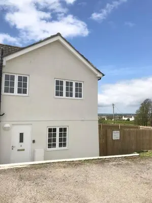 a white house with a fence in front of it at Great location very spacious. Sea and castle view in Marazion